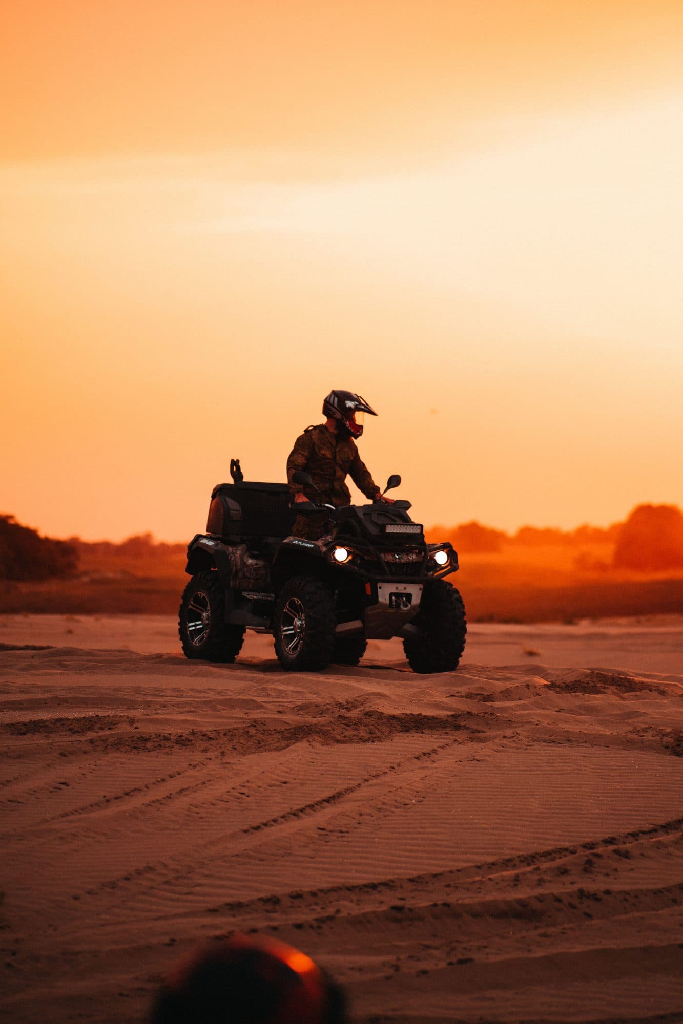 A single rider in a helmet on a quad at All New Bali Adventure in Sedang at sunset