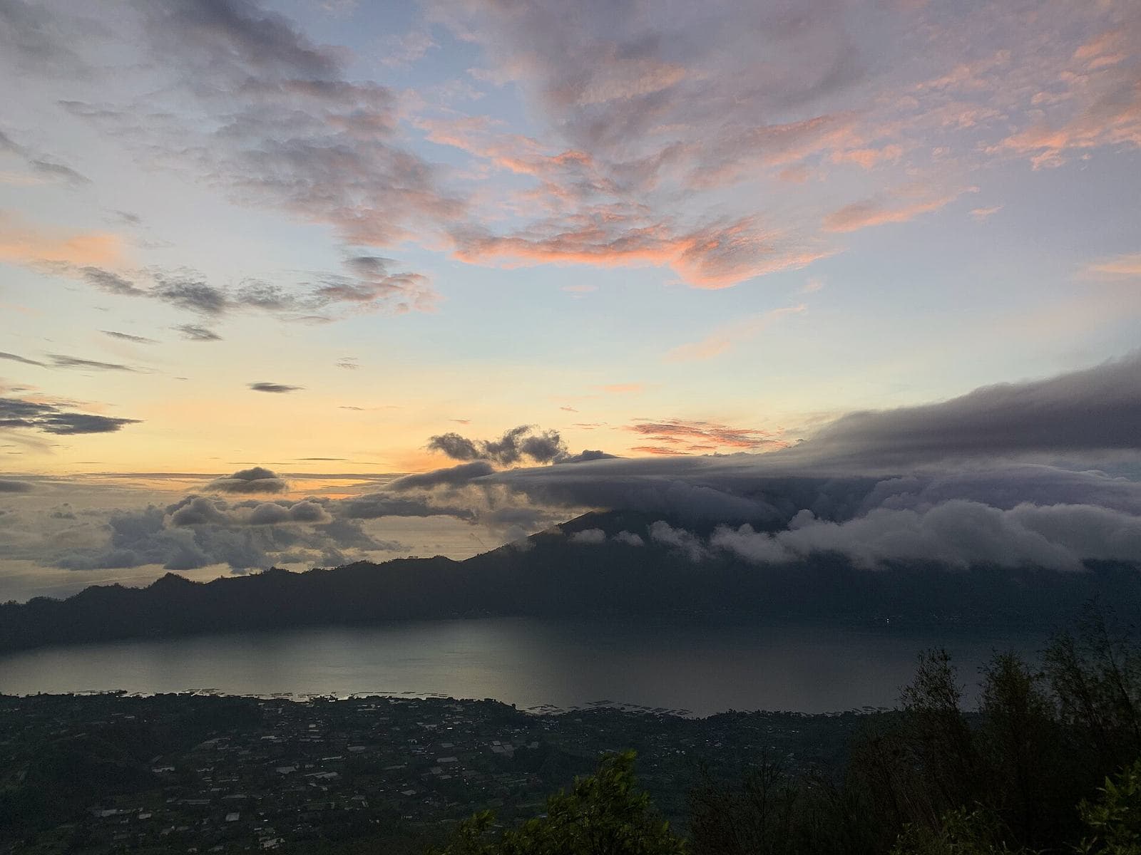 Orange sunrise over Mount Batur with a summit marker in the foreground